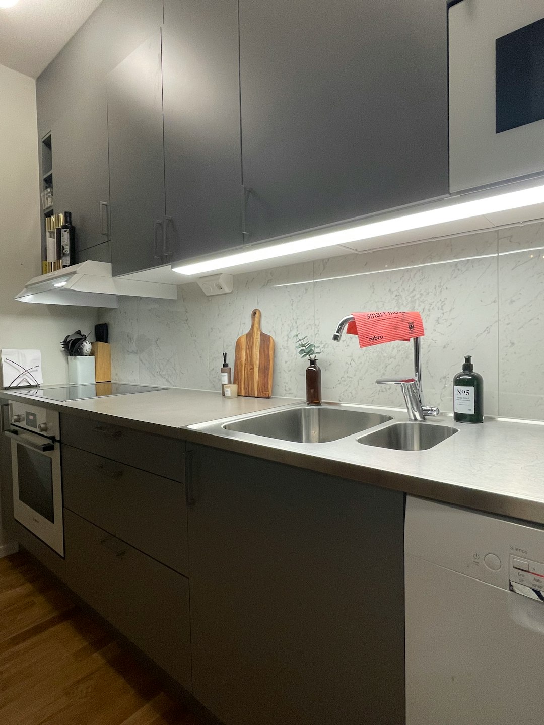 A clean grey kitchen with marble tiles